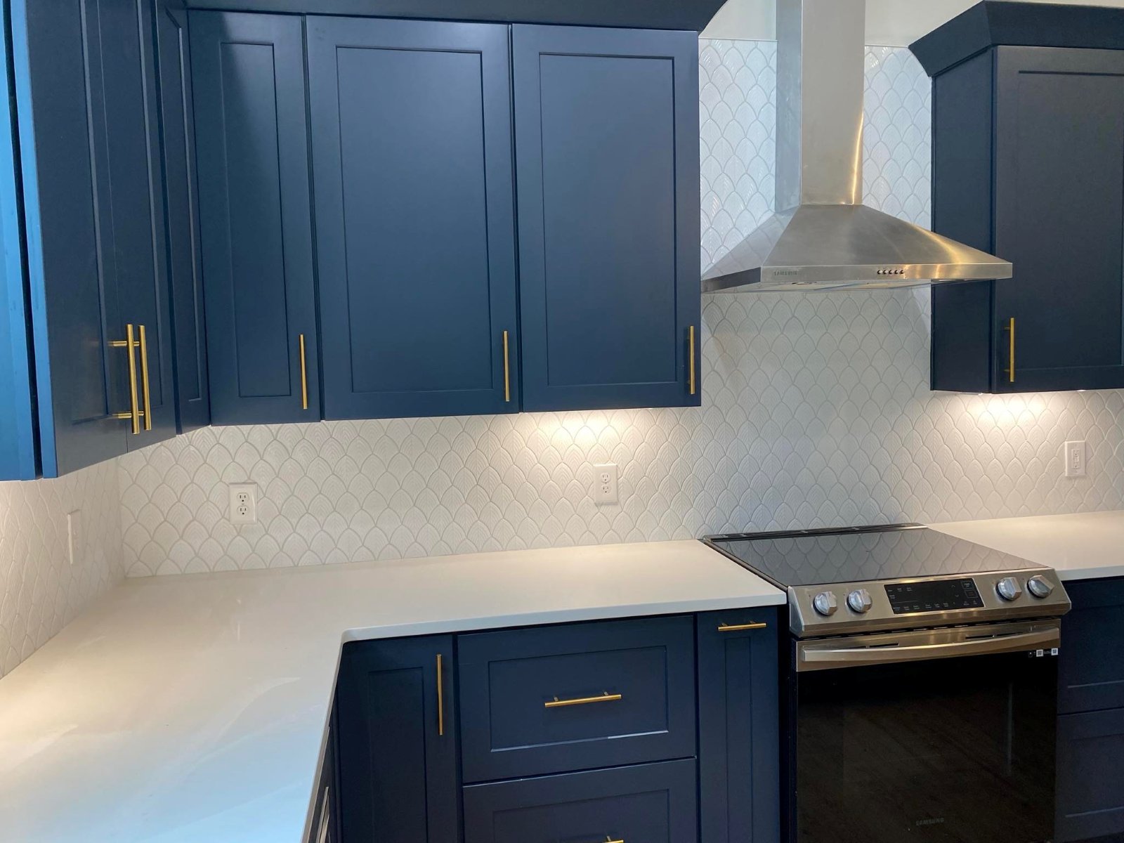 White scalloped tile backsplash with navy cabinets installed by Genis Pacific